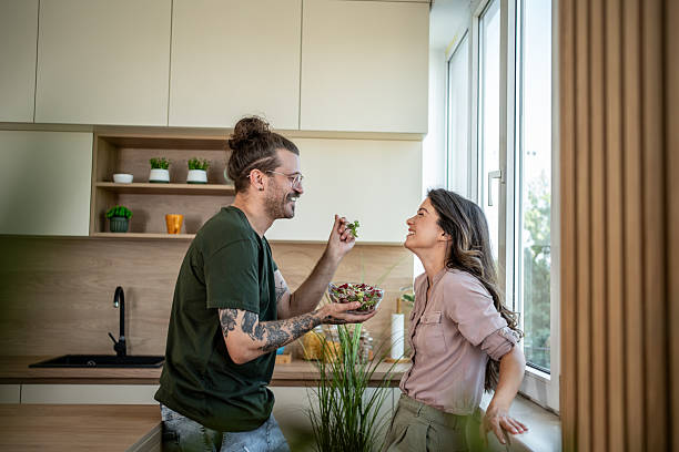 istock Happy couple sharing a salad in their modern kitchen 2222067346