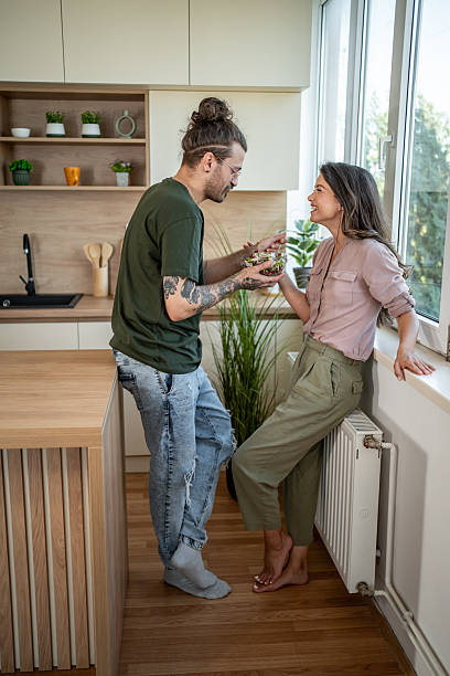 istock Young couple sharing a salad in their modern kitchen 2222067358