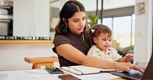 istock Laptop, multitask or remote work with mother and baby in home for development of small business. Busy, computer or typing with single parent and child in apartment for freelance or startup career 2222068415