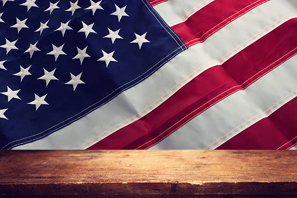 istock Background of American flag with festive bright lights and empty table 2222069598