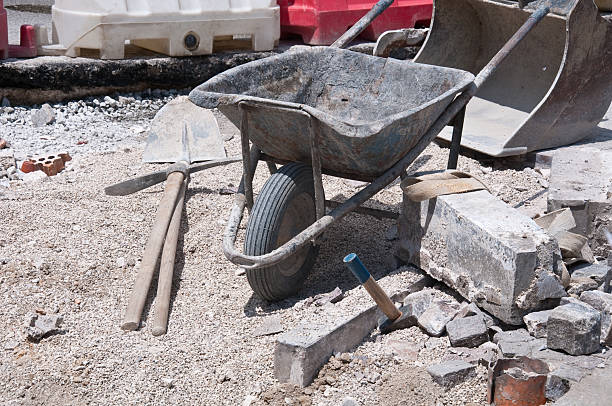 work on the road with wheelbarrow , a pick and hammer, men at work