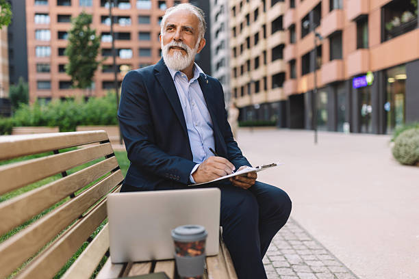 istock Contemplative senior man writing in quiet park 2222075316