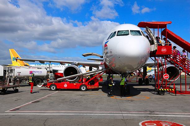 Passengers board Air Asia Airbus A320 at Ninoy Aquino International Airport (NAIA), Manila. The airport handles 36.7 million passengers annually (2015).