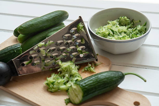 istock Grated and whole cucumber on cutting board 2222082098