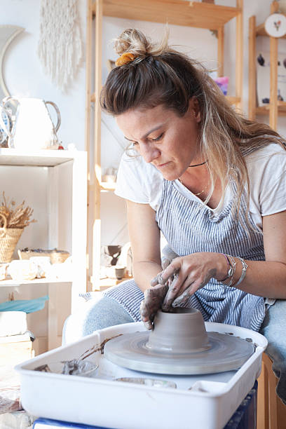 istock Focused ceramic artist shaping a clay bowl on pottery wheel 2222091255