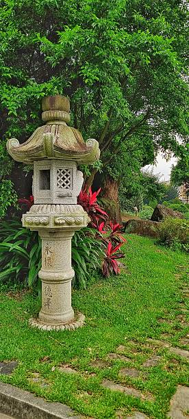 istock Japanese stone lantern within a lush green garden setting 2222091977