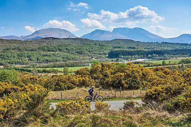 woman cycling below Ben Nevis summit, Scotland, UK