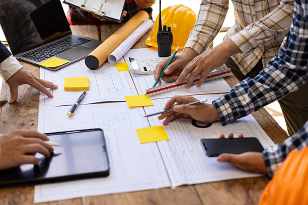 istock Team of architects and engineers working on construction project. Architect and engineer are using pencil, ruler on table with blueprint to discuss construction project. Construction design planning. 2222096940