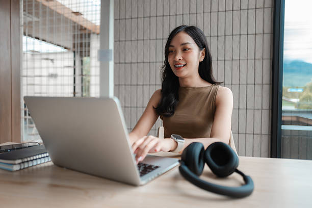 istock Young Asian woman working remotely using laptop, enjoying the flexibility and convenience of modern workspace 2222097422