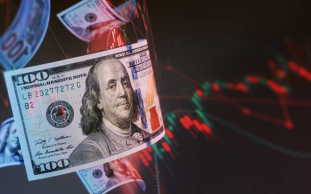 istock 100 Dollar Bills Flying in the Air on Finance Graph Background 2222098757
