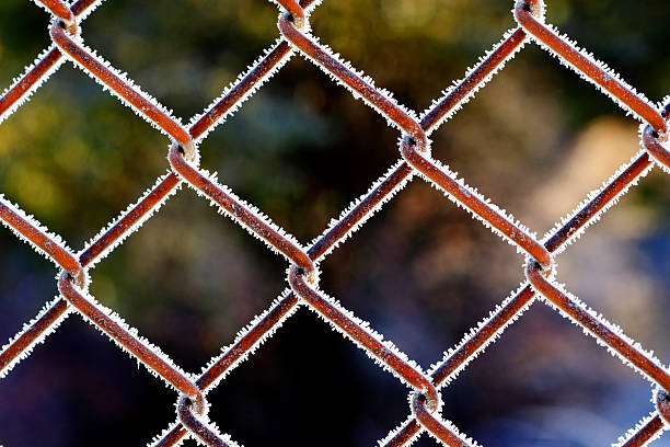 Detail of chainlink chain link fence with icy frost crystals during bitter cold winter freezing