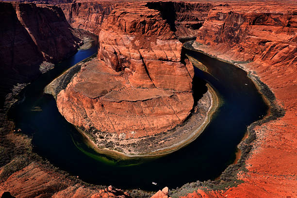 Curve in Colorado River at Horseshoe Horse Shoe Bend with red rock cliffs and blue water flowing