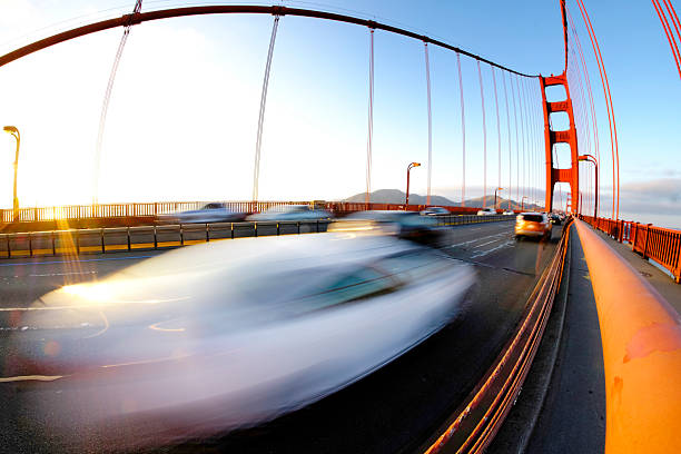 Golden Gate Bridge in San Francisco at evening with sunlight and traffic driving