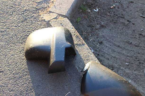 istock Broken Side Mirror on Pavement Detail in Sunlight Closeup 2222107991