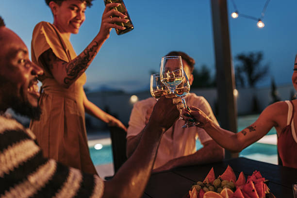 istock Friends toasting with white wine glasses at luxury resort poolside 2222109257