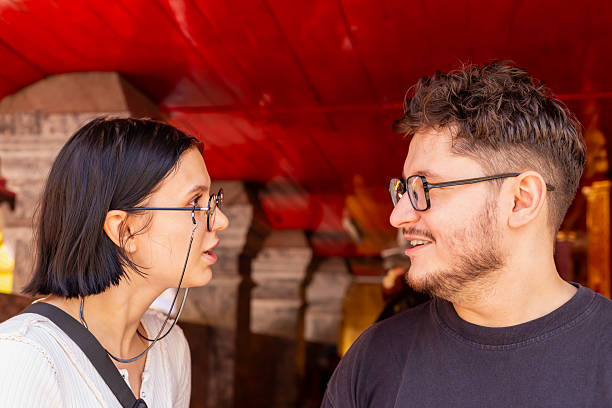 Young couple is having spirited discussion outdoors, with colorful architecture in background