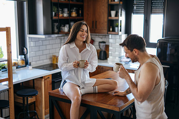 istock Young couple laughing and drinking coffee in the kitchen 2222109750