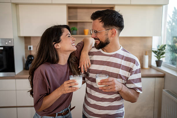 istock Happy couple drinking milk in modern kitchen, embracing domesticity 2222110404