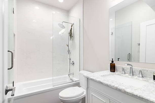 istock A bathroom with a white cabinet and countertop and a tiled shower. 2222112408