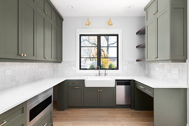 istock A modern kitchen with green cabinets and a tiled backsplash. 2222112616