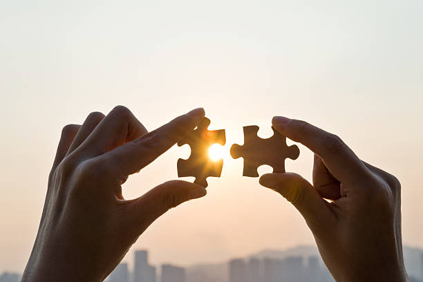 istock Woman hand putting puzzle pieces together in sunset 2222112986