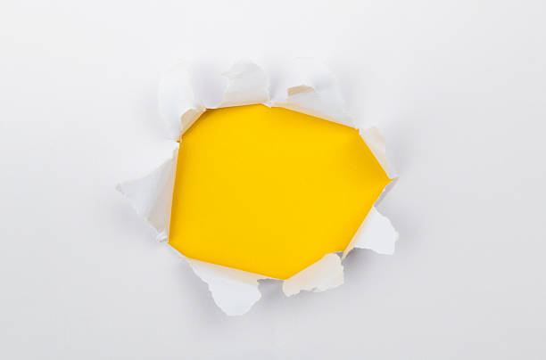 istock Torn white paper hole reveals yellow background 2222113904