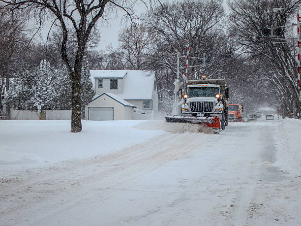 Winnipeg, Manitoba, November 11, 2012:  A snowplough pushes through deep snow on a quiet residential street, clearing a path after a winter storm.
