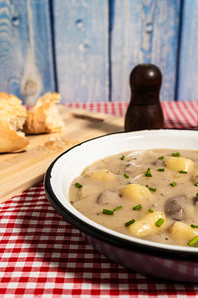 istock Creamy mushroom soup with potatoes and chives garnished on rustic table 2222118226