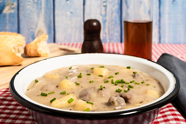 istock Delicious beef stew with dumplings garnished with chives in rustic setting 2222118228