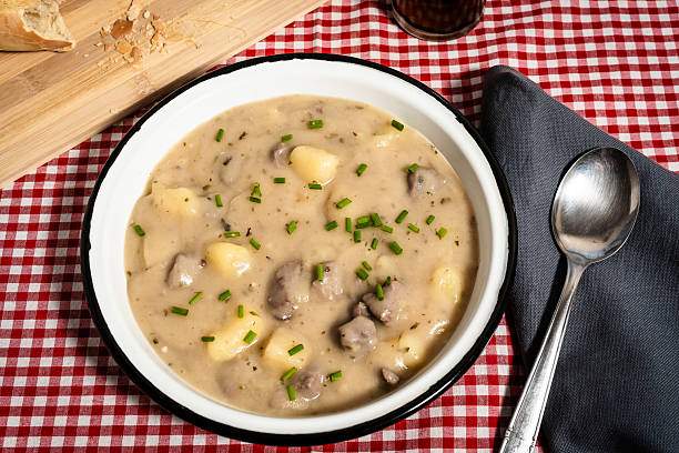 istock Delicious creamy potato soup with meat and chives garnished in rustic setting 2222118230