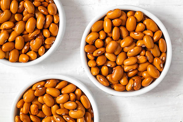 istock Three white bowls with yellow organic beans on a white background. Top view. 2222118329