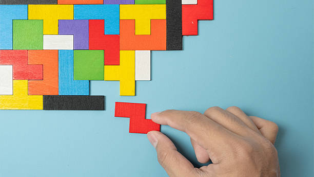 istock hand connecting geometric shape block with colorful wood puzzle pieces. logical thinking, business logic, Conundrum, decision, solutions, rational, mission, success, goals and strategy concepts 2222118428