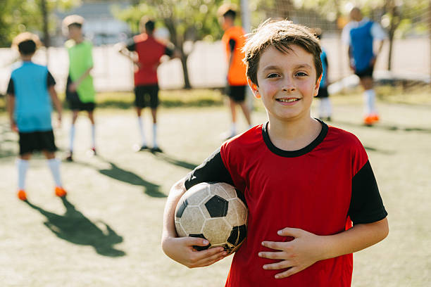 istock Smiling Youth Soccer Player Holding Ball on Field During Practice 2222118917