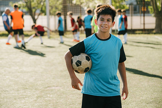 istock Smiling Boy Holding Soccer Ball During Practice On A Sunny Field 2222119159