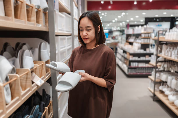 istock Customer browsing and selecting cozy slippers in a houseware store, engaging in a shopping lifestyle experience 2222120130