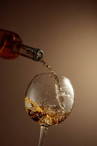istock Pouring white wine from a bottle into a glass. 2222120281