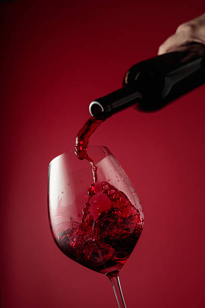istock Pouring red wine from a bottle into a glass. 2222120283