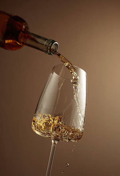istock Pouring white wine from a bottle into a glass. 2222120284