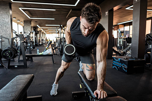 istock Fit Man Exercising with Dumbbells at Gym 2222120318
