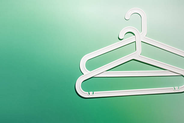 istock Top view White Plastic hangers, minimal style layout on white green gradient background, Clothes rack for organizing clothes in closets or retail stores, fashion, organization concept, copyspace 2222124582