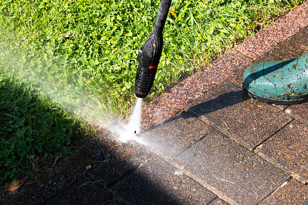 istock Cleaning pavement with pressure washer at garden grass edge. Visible before-and-after effect when pressure cleaning paving stones 2222126179