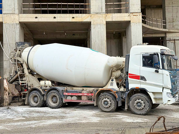 istock Concrete Mixer Truck Positioned at Construction Site with Partially Built Structure 2222126492