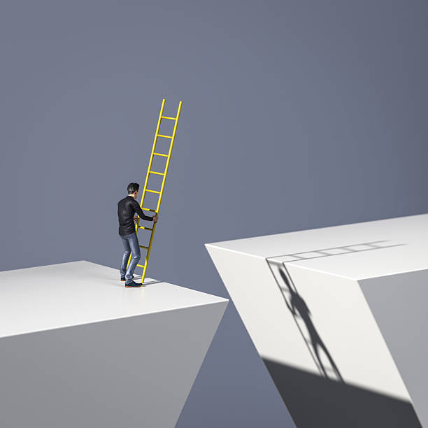 istock A man standing at a gap and trying to bridge it with  a ladder. Concept for taking risks, courage, the way forward, finding solutions. 2222127306