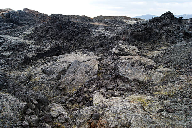 Jagged volcanic rocks dominate a barren Icelandic landscape.