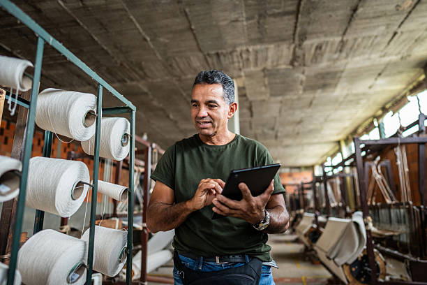 Mature man using digital tablet to control stock at textile industry