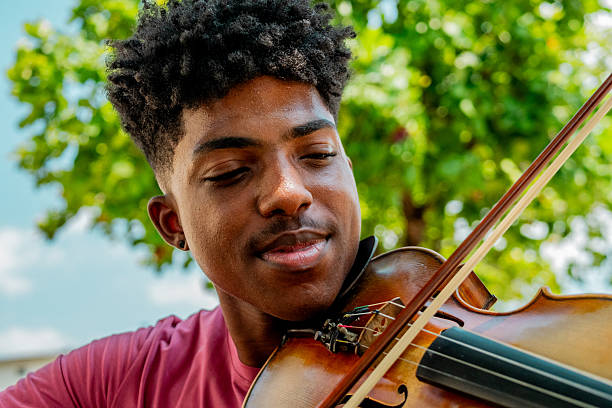 Young man playing violin outdoors