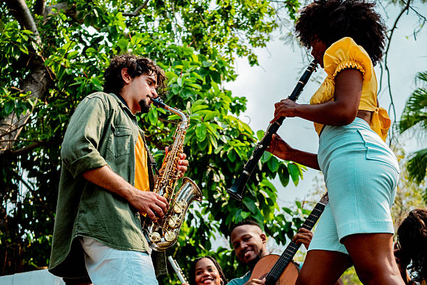Musician friends playing instruments on public park