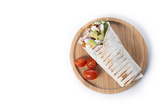 A delicious grilled chicken wrap with vegetables isolated on white background