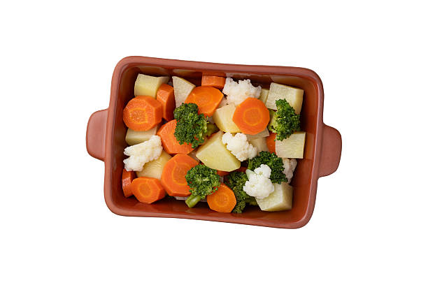 Cooked vegetables in a plate isolated over white background.