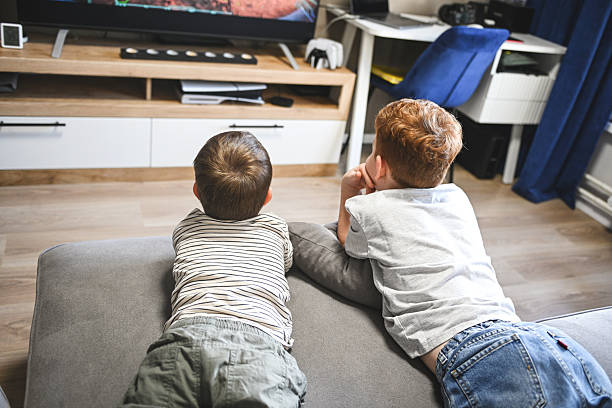 istock Two little brothers watching cartoons and playing games 2222148782